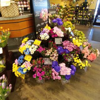 A vibrant display of assorted flowers in a grocery store.