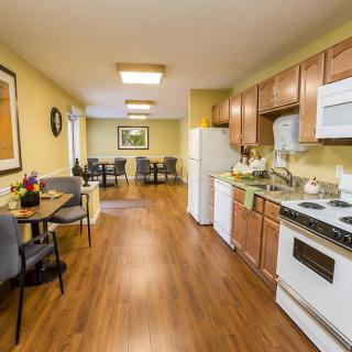 A cozy kitchen and dining area with wooden flooring, modern appliances, and comfortable seating.