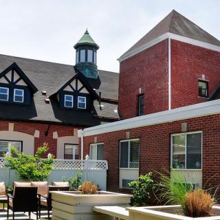 A charming building with brick exterior and outdoor patio seating.