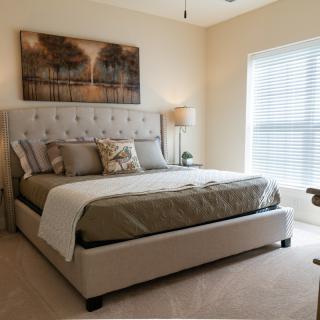 A cozy, well-decorated bedroom featuring a large bed and soft lighting.