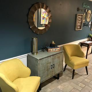 A cozy living room setup featuring yellow chairs and stylish decor on a blue wall.