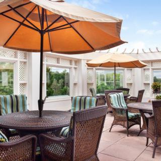 A cozy outdoor patio with tables and chairs under large umbrellas.