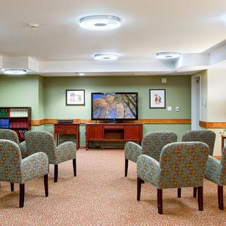 A meeting room with chairs facing a television.
