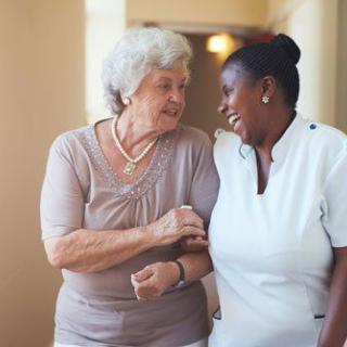 A caregiver and an elderly woman sharing a happy moment together.