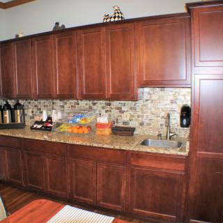 A modern kitchen with wooden cabinets and a granite countertop.