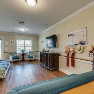 A cozy living room with seating, a television, and various decorations.