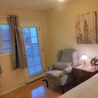 Cozy bedroom with a comfortable chair and soft lighting.