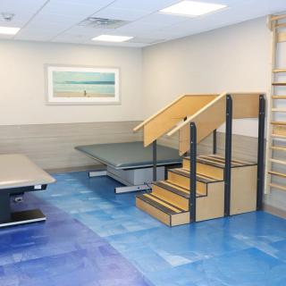 A physical therapy room with exercise equipment and rehabilitation tools.
