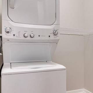 A stacked washer and dryer unit in a laundry area.