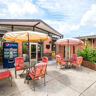 A cozy outdoor seating area with colorful umbrellas, perfect for enjoying a drink on a sunny day.