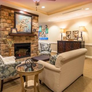 A warmly lit living room featuring a stone fireplace, comfortable sofas, and elegant home decor.