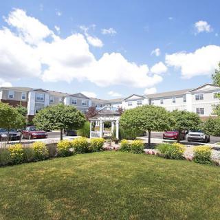 A residential building with a landscaped garden and clear blue sky.