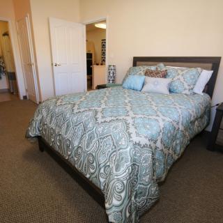 A cozy bedroom with a neatly made bed and decorative pillows.