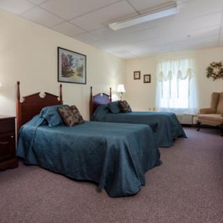 A cozy hotel room featuring two twin beds and a comfortable sitting area.