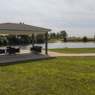 A serene lakeside view with a gazebo and outdoor seating.