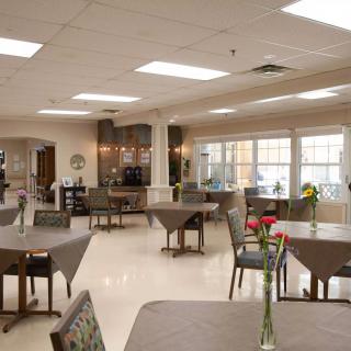 A spacious and well-lit dining area with neatly arranged tables and chairs.