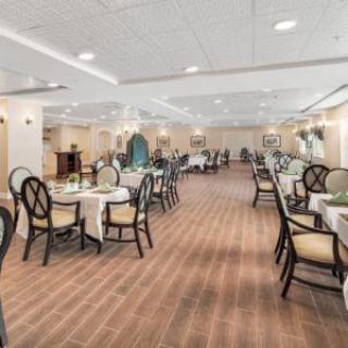 A spacious and elegantly decorated dining area with neatly arranged tables and chairs.