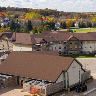 A scenic view of a neighborhood with autumn foliage in the background.