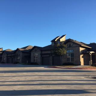 A row of suburban houses under a clear blue sky.