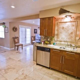 A modern kitchen with wooden cabinets and stainless steel appliances in an open layout.
