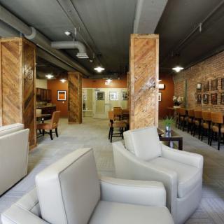 A modern lounge area featuring comfortable seating, decorative columns, and artwork on the walls.
