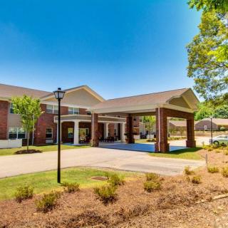 A sunny day view of a building entrance with landscaped surroundings.