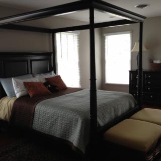 A stylish bedroom featuring a canopy bed and modern decor.