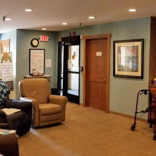 A cozy reception area with armchairs and framed artwork on the walls.
