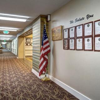 A hallway adorned with an American flag and a series of tribute plaques on the wall.