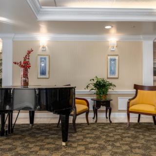 A sophisticated lounge area featuring a grand piano, elegant seating, and tasteful decor.