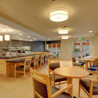 A modern dining area with tables, chairs, and ambient lighting.