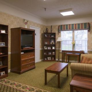 Comfortable living room with a TV, bookshelves, and cozy seating.
