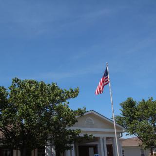 A building with an American flag on a clear day.