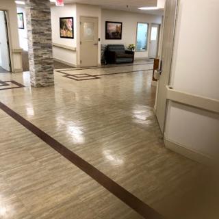 A well-lit hallway featuring polished floors and seating areas.