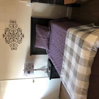 A neatly arranged bedroom with patterned bedding and stylish wall decor.