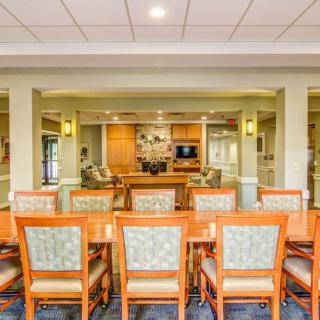 A modern dining room interior with wooden furniture and ambient lighting.