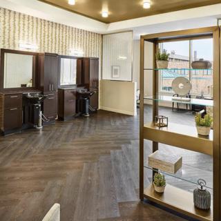 A stylish salon interior featuring modern hairdressing stations and chic decor.