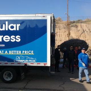 A delivery truck from a service company with people gathered nearby.
