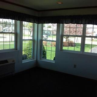 An empty room with large windows providing a view of the outdoors.