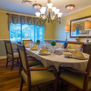 A beautifully set dining table in an elegantly designed room, featuring a chandelier and tasteful decor.