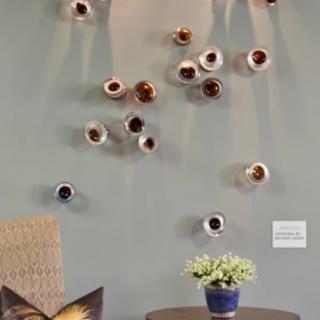 A modern living space featuring a unique ceramic wall installation with small planters on a neutral green wall.