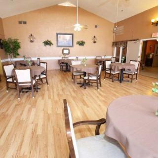 A cozy dining area with neatly arranged tables and chairs on a wooden floor.