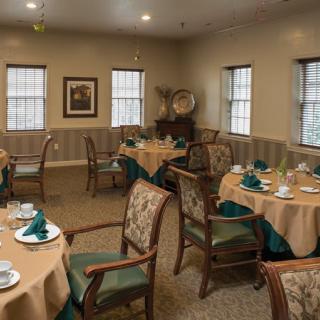 A cozy dining room with tables and chairs set for a meal.