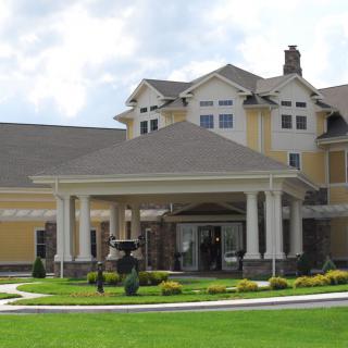 A large residential building with landscaped surroundings and a covered entrance.