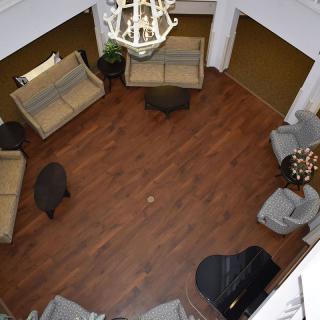 A spacious lobby area with various seating arrangements and a grand piano.