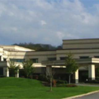 A modern hospital building with a well-maintained exterior and surrounding greenery.
