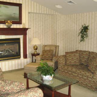 A cozy living room with a fireplace, floral-patterned furniture, and decorative elements.