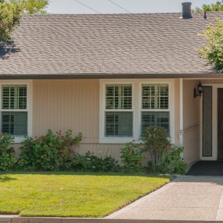 A suburban house with a well-maintained front yard and green landscaping.