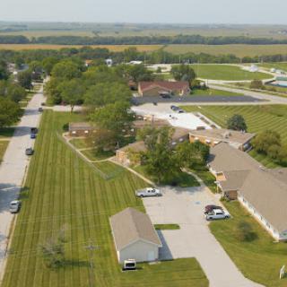 Aerial view of a rural community featuring well-maintained buildings and green landscapes.
