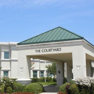 A hotel entrance with a green roof and landscaped surroundings.